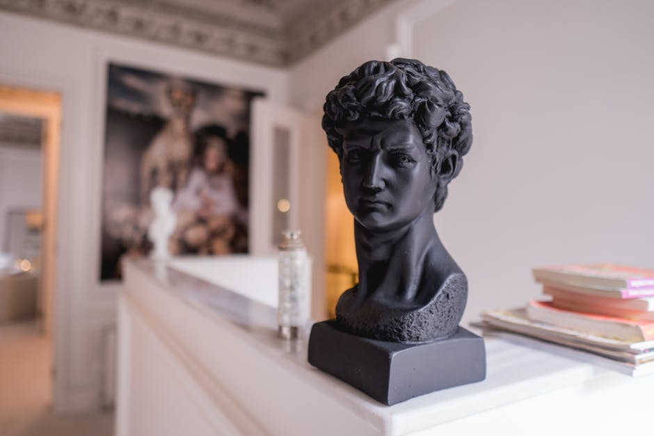 A black sculpture of a man's bust displayed elegantly in a sophisticated art gallery setting.