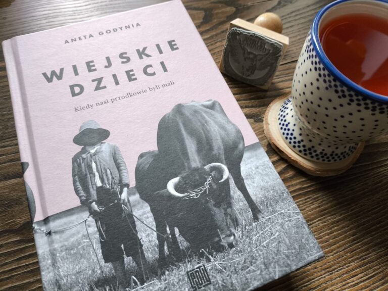 Książka o historii przodków Wiejskie dzieci w przytulnej aranżacji z ceramicznym kubkiem herbaty na drewnianym stole