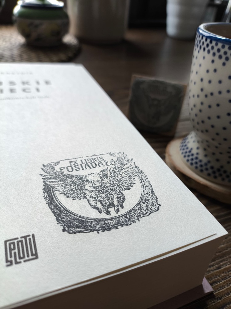 Zbliżenie na osobisty ekslibris z symbolem latającej świnki odbity na stronie tytułowej książki Wiejskie dzieci.