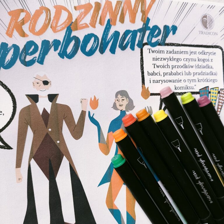 Karta pracy "Rodzinny Superbohater" marki Tradicon leżąca na biurku, obok kolorowych mazaków. Na karcie widoczne są ilustracje postaci w stylu komiksowym oraz instrukcja zadania dotyczącego odkrywania historii przodków.